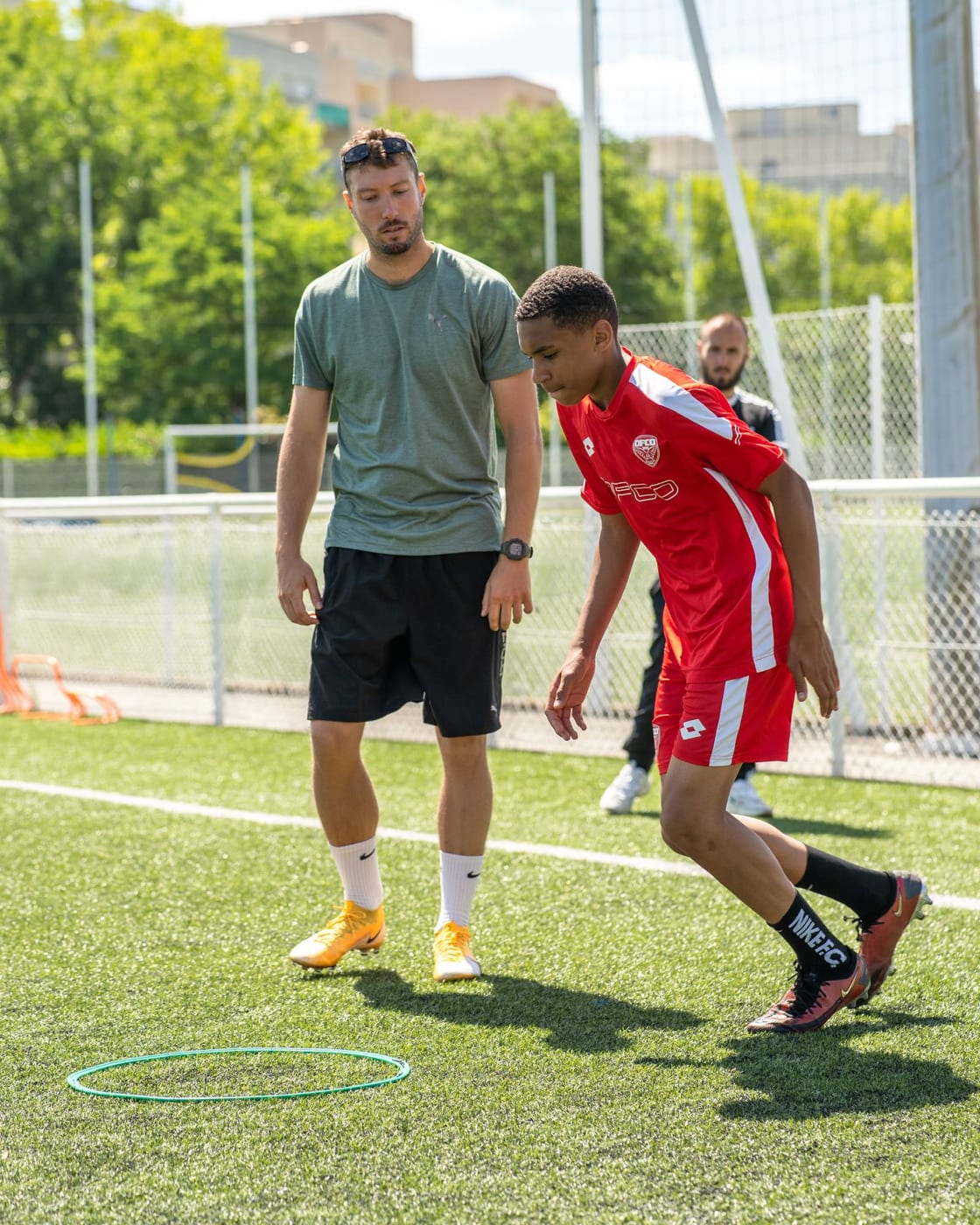 Le coach observe un jeune joueur sur le terrain